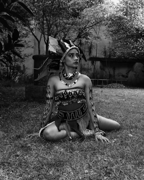 A woman in a native american costume sitting on the ground