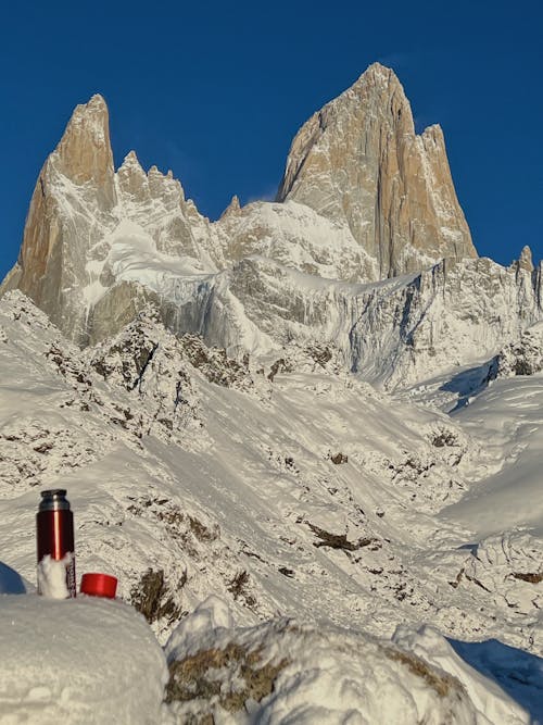 A red cup sitting on top of a snow covered mountain