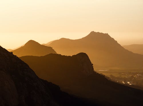A sunset over the mountains with a silhouette of a person