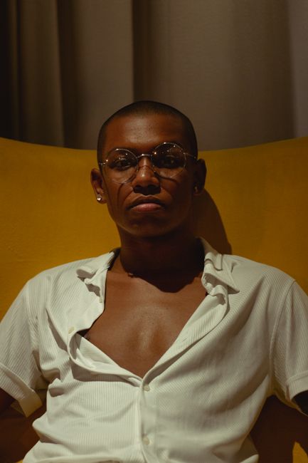 Stylish portrait of a man wearing eyeglasses and a white shirt.