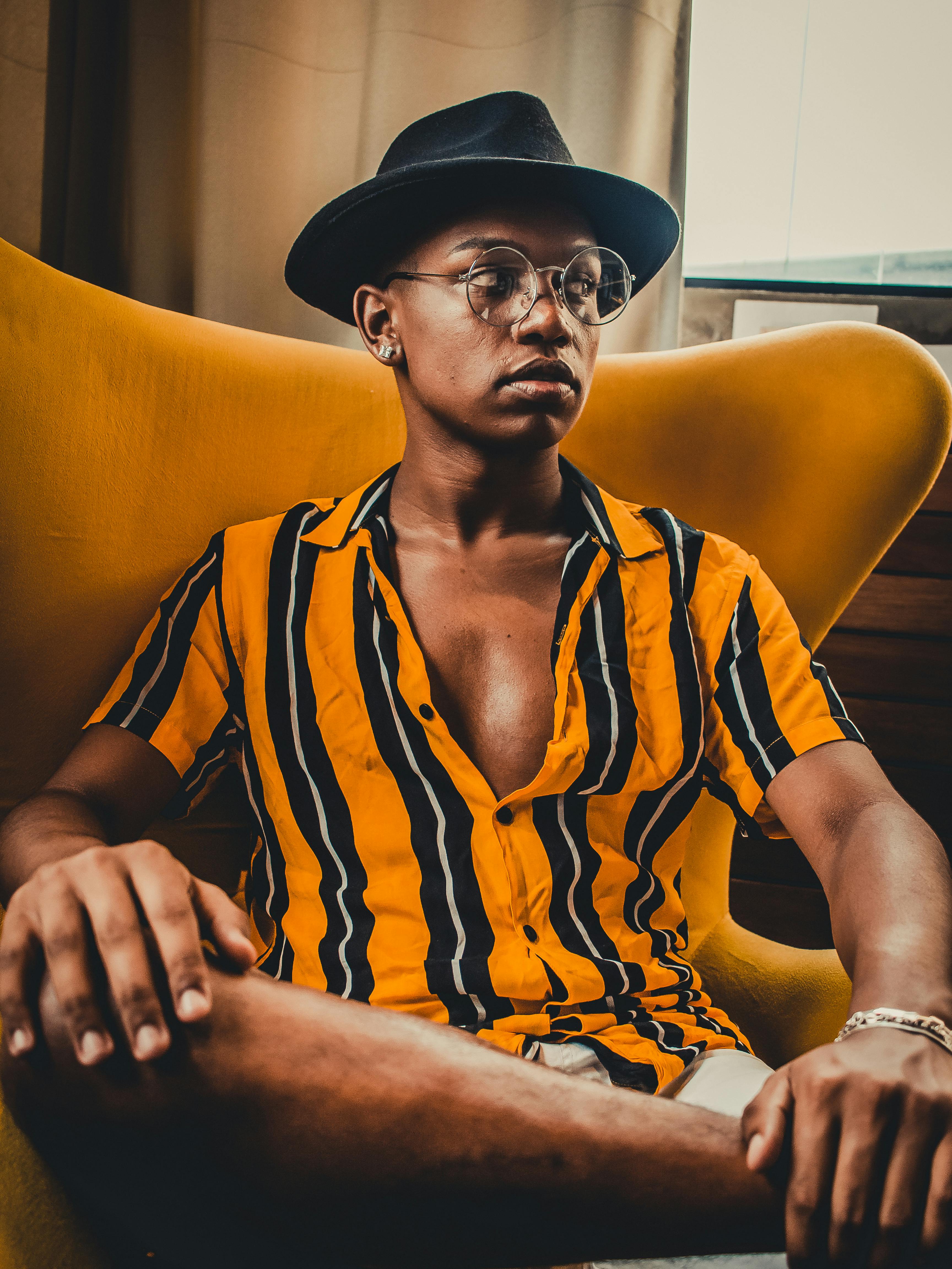 Bezpłatne Mężczyzna Siedzi Na Krześle Patrząc W Lewo Zdjęcie z galerii