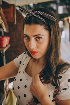 这是一幅室内肖像，画中是一位身穿圆点连衣裙、留着复古发型的年轻女子