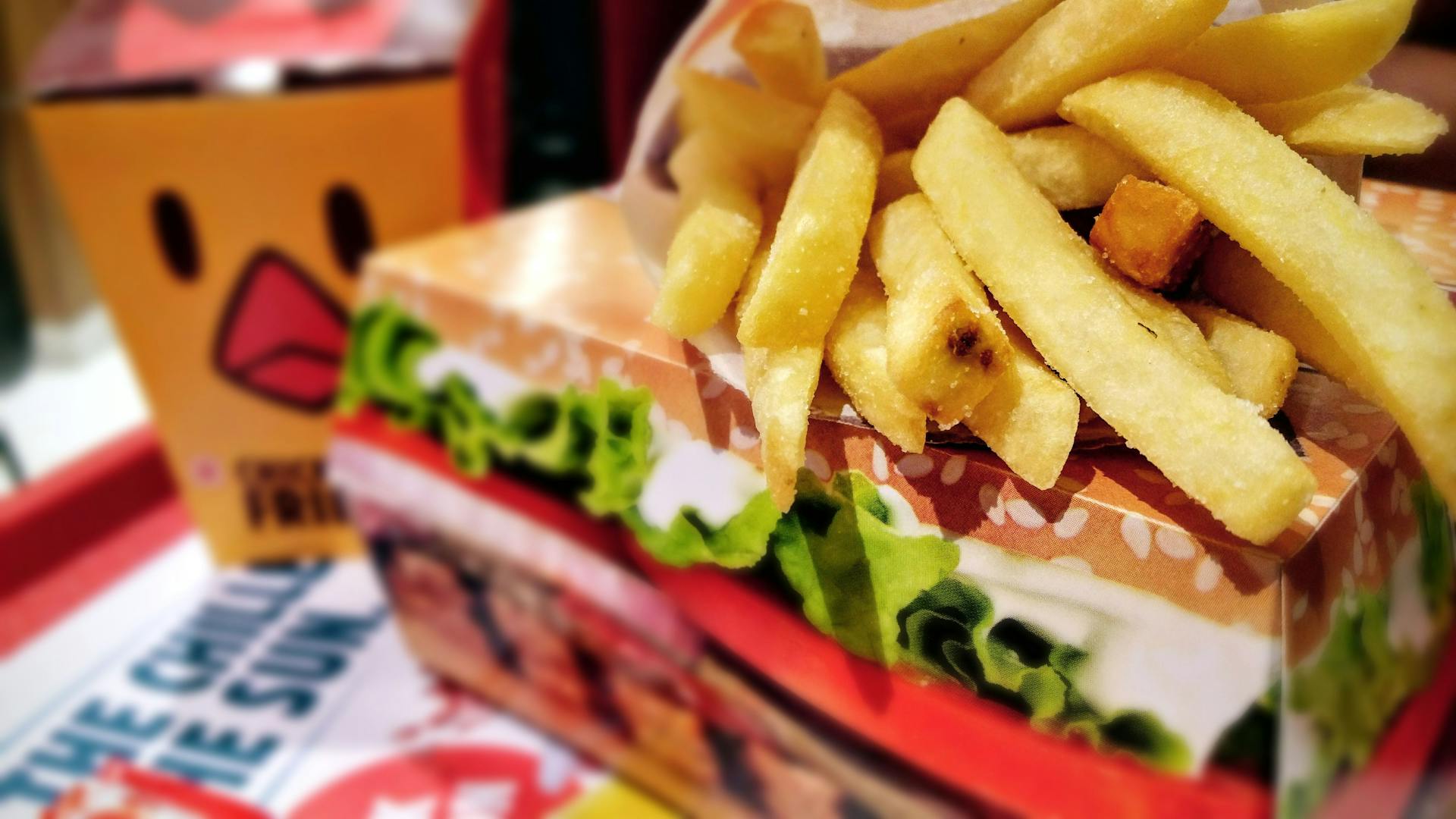 Crispy french fries served on a fast food tray with vibrant packaging.