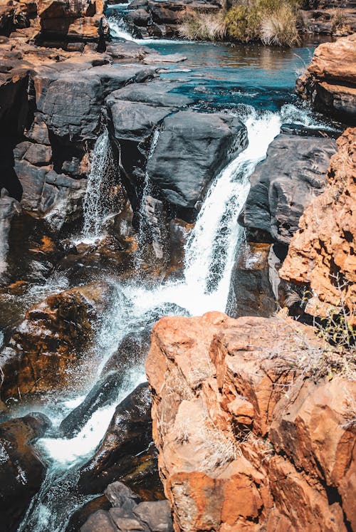 A waterfall is flowing over rocks in the desert