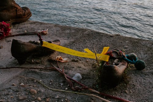 A pair of shoes and a yellow ribbon on the ground