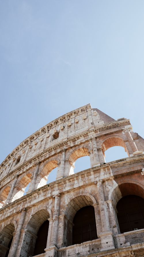 Free Low angle view of the ancient Colosseum in Rome against a clear blue sky. Stock Photo