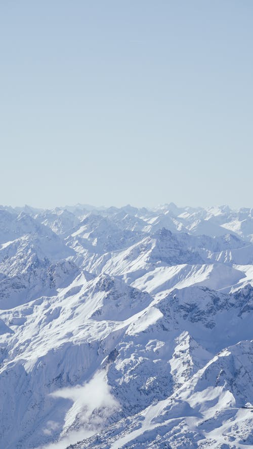 A person is standing on top of a snow covered mountain