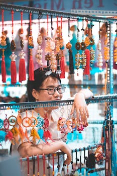 亚洲妇女在市场的摊位上出售色彩鲜艳的悬挂装饰品