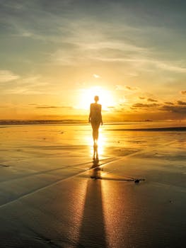 日落时分，巴厘岛海滩上孤独的剪影，营造出色彩鲜艳的戏剧场景