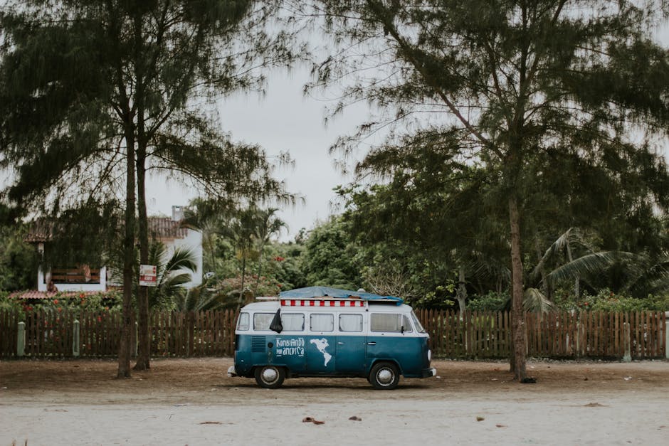 A classic blue Volkswagen van parked along a scenic beach in Olon, Ecuador.