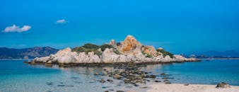 蔚蓝的天空下，宁静海滩的全景中，岩石结构令人惊叹