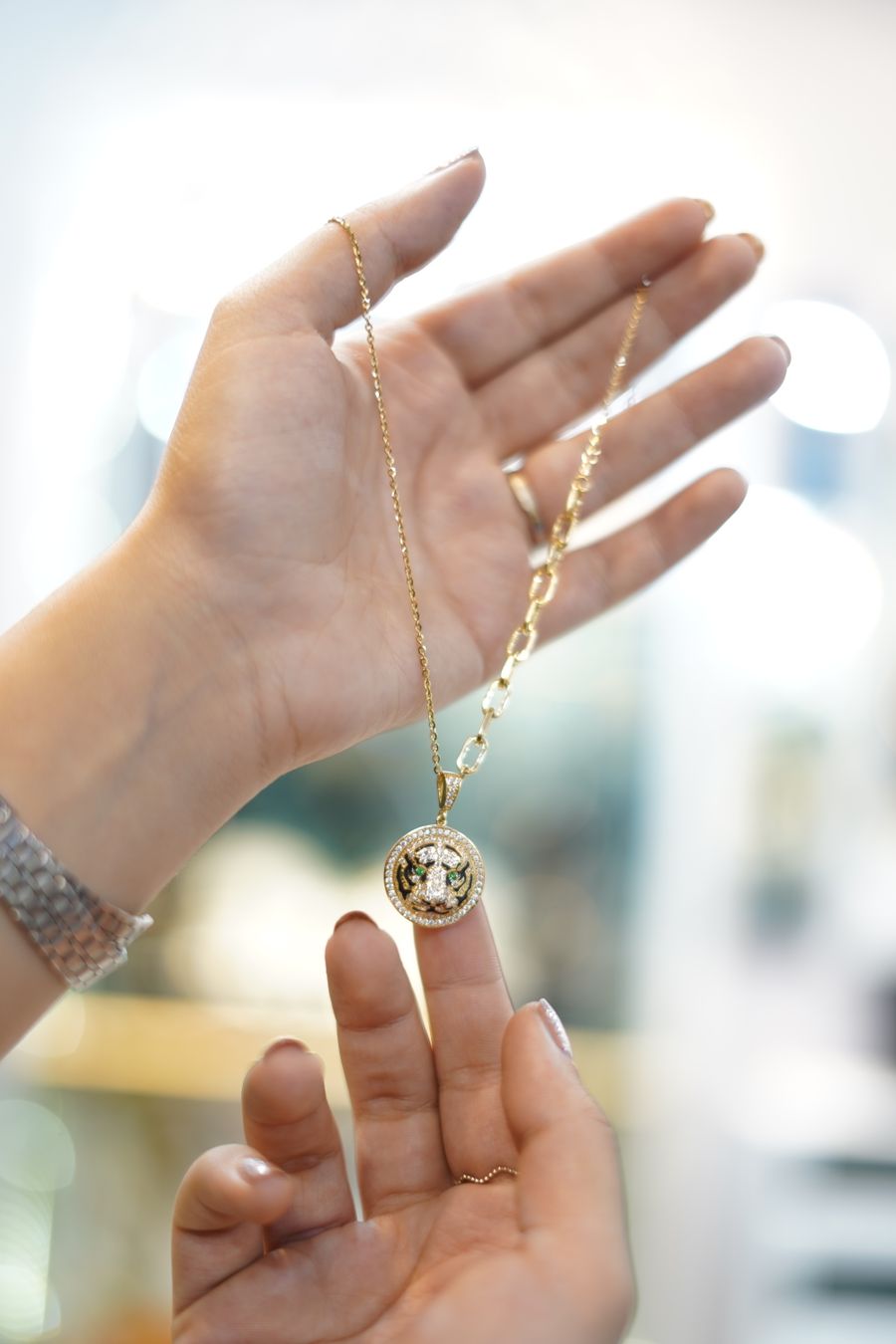 Woman holding a gold pendant necklace