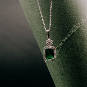 Silver chain pendant with green stone, photo by Diun group on Pexels