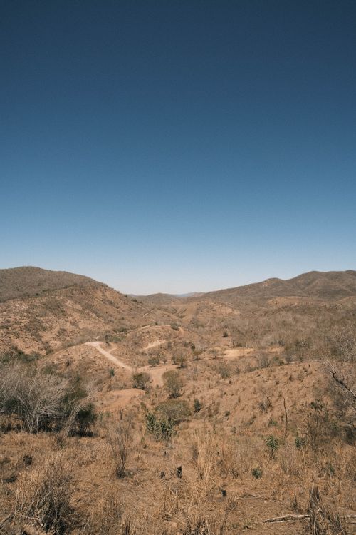 Free A scenic view of dry, rolling hills under a clear blue sky, capturing a sense of tranquility and vastness. Stock Photo
