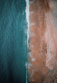 Stunning aerial shot of Byblos beach with turquoise waves and brown sand.
