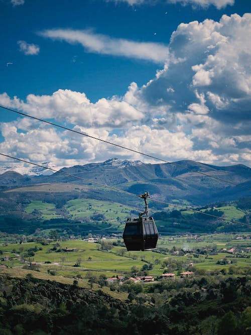 A cable car in the mountains with a cloudy sky