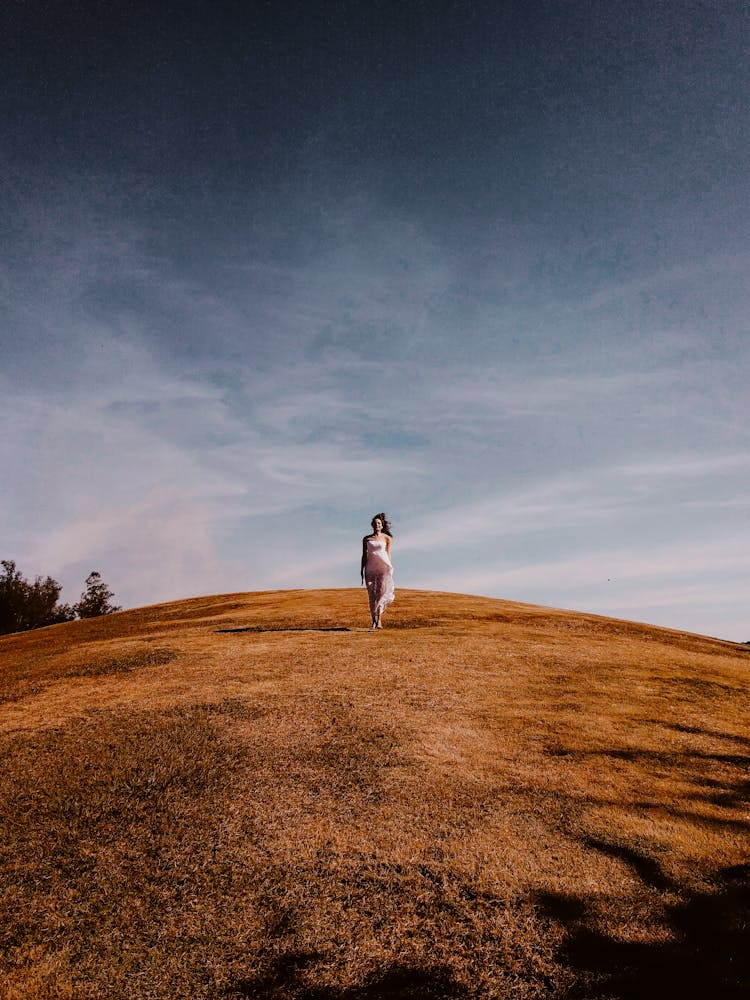 Photo Of Woman Standing On Grass Hill