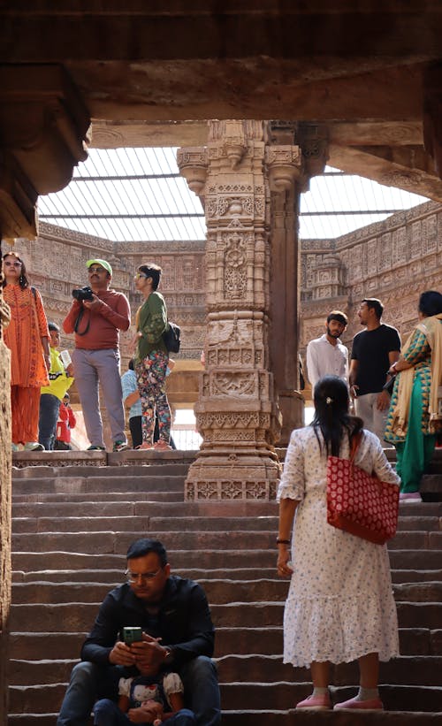 People sitting on steps in front of a temple