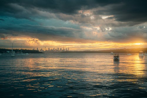 A boat is floating in the water at sunset