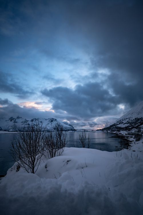 Free Captivating winter scene of snowy mountains reflecting in a tranquil lake at twilight. Stock Photo
