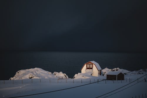 A house sits on the shore of a frozen lake