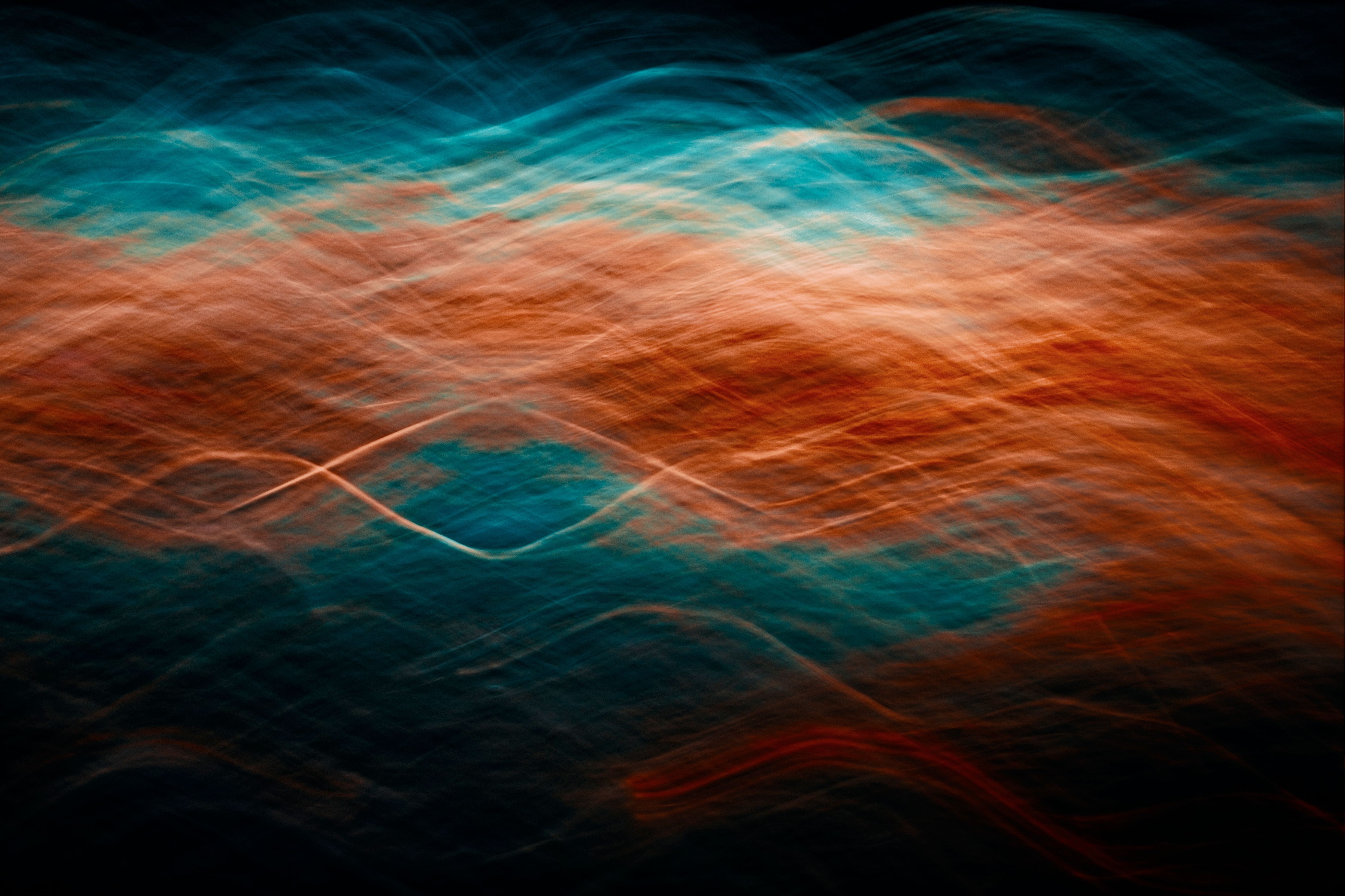 Dynamic abstract image of vibrant waves of light in blue and orange hues.