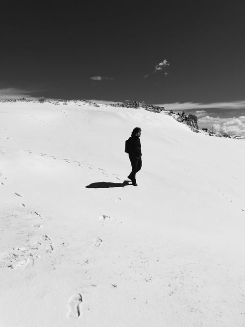 Free A lone hiker walks through snowy terrain on Monte Baldo, capturing the serenity of winter. Stock Photo
