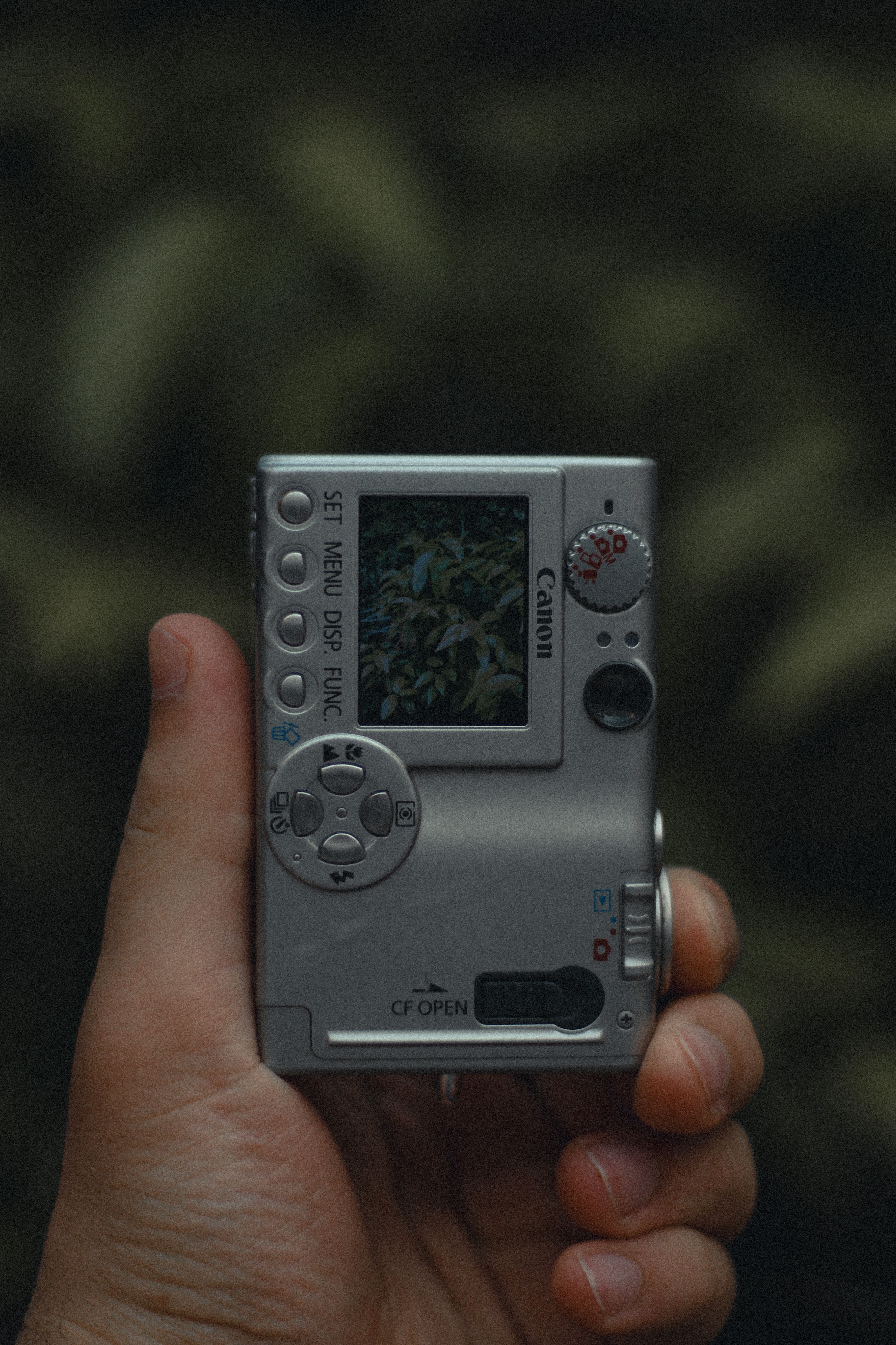 Close-up of a hand holding a digital camera outdoors in Peshawar, Pakistan.