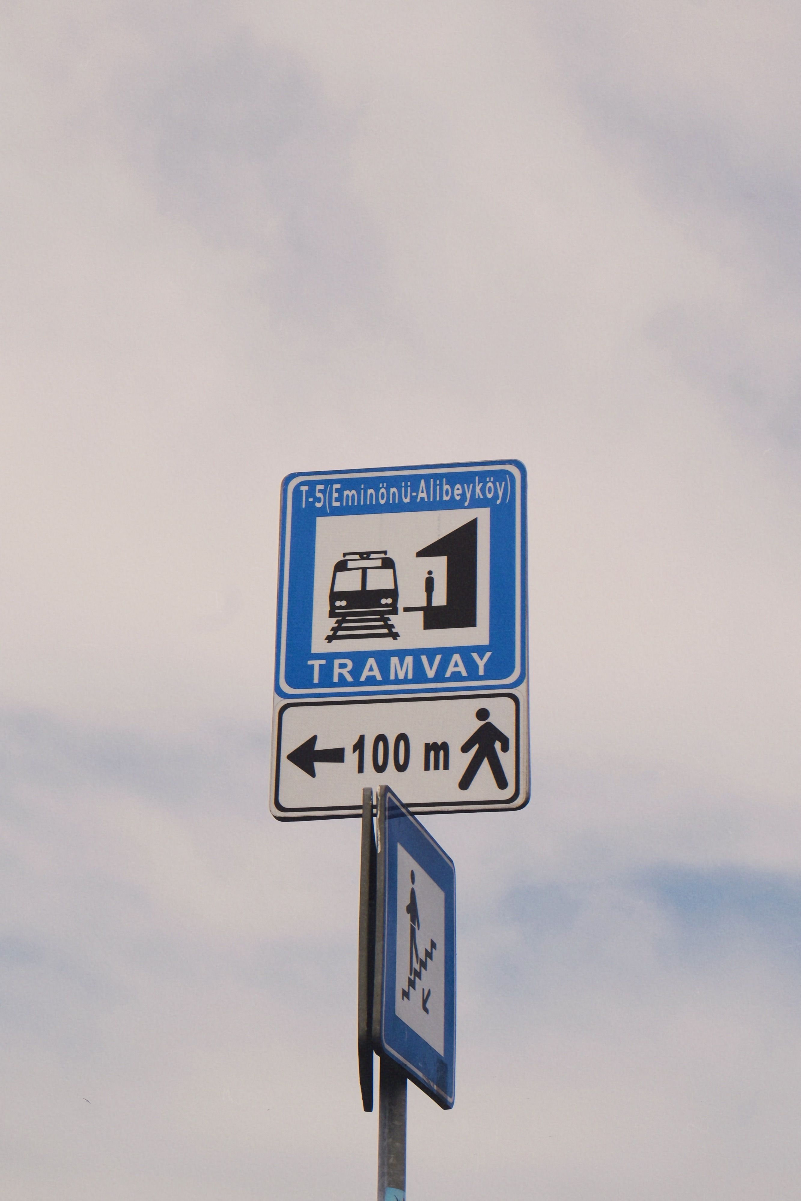Tramway road sign in Istanbul showing direction and distance under a clear sky.
