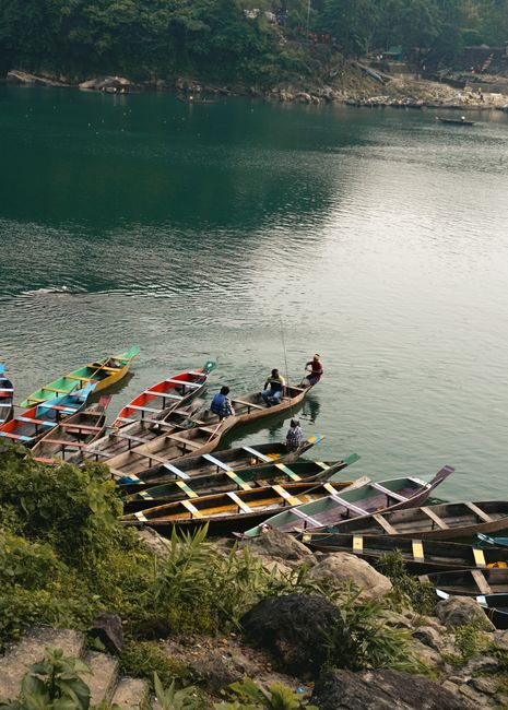 A scenic view of colorful canoes moored by a tranquil water body in Bengaluru, India.