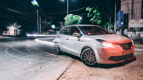 Long Exposure Photography of Silver Suzuki Dezire on Road