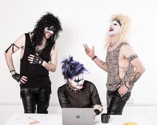Free Three adults in goth makeup and clothing enjoying time together indoors with a laptop. Stock Photo