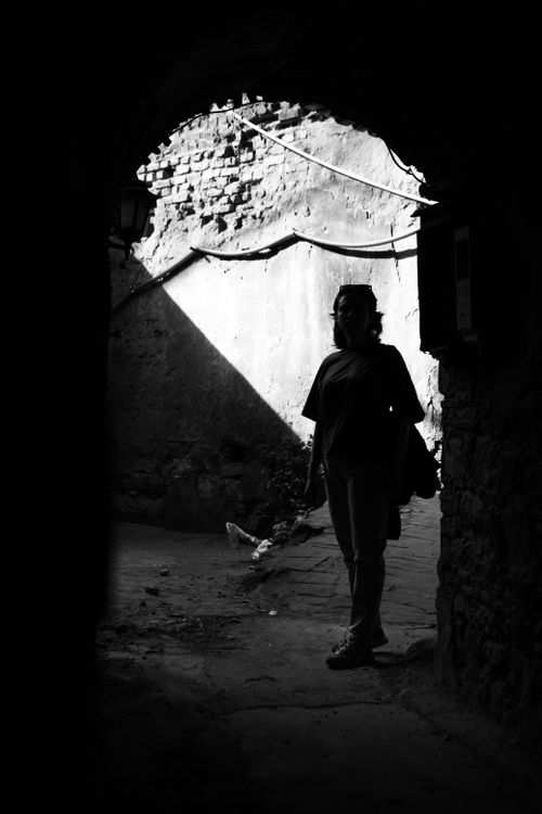 Free Dramatic black and white photo of a person silhouetted in an urban alley, conveying mystery. Stock Photo
