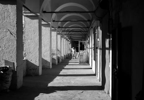 A black and white photo of a long hallway