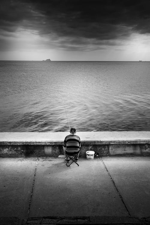 A man sitting on a bench looking out to the ocean
