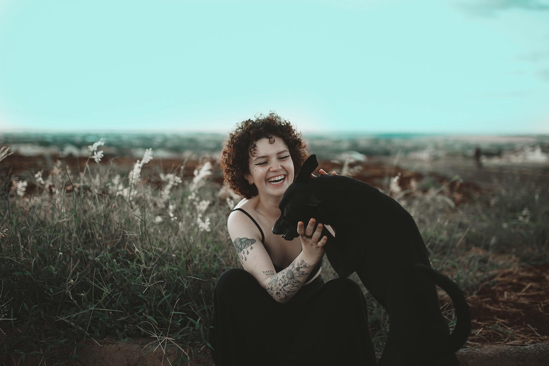 Photo of Smiling Woman Petting Black Dog