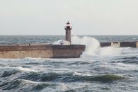 阳光明媚，海浪汹涌，波尔图海岸线上的灯塔营造出戏剧性的海景