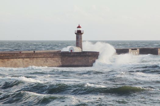 阳光明媚，海浪汹涌，波尔图海岸线上的灯塔营造出戏剧性的海景