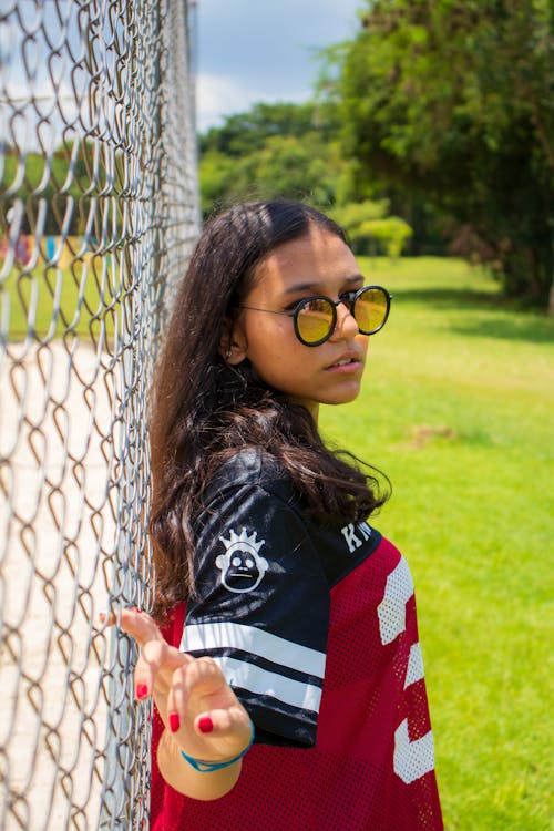 Woman Leaning On Chain-link Fence