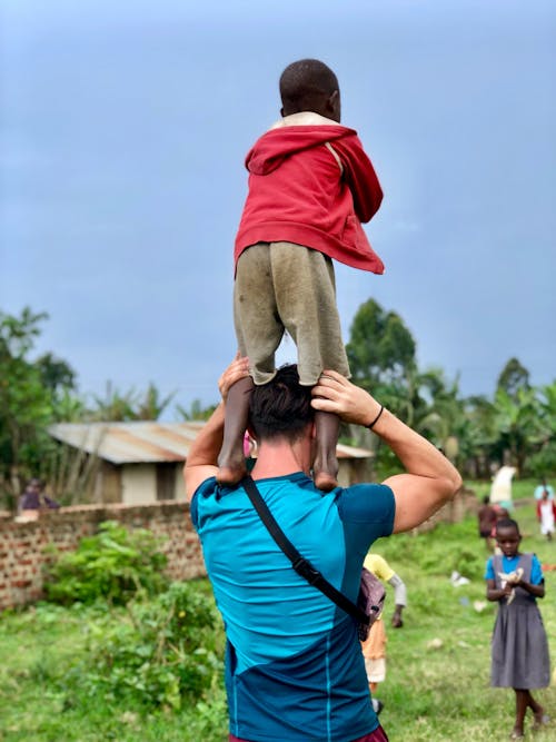 Man Carrying Boy On Shoulders