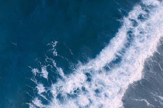 航拍镜头中，海浪拍打海岸线的景象令人惊叹，展示了大自然的美丽与力量