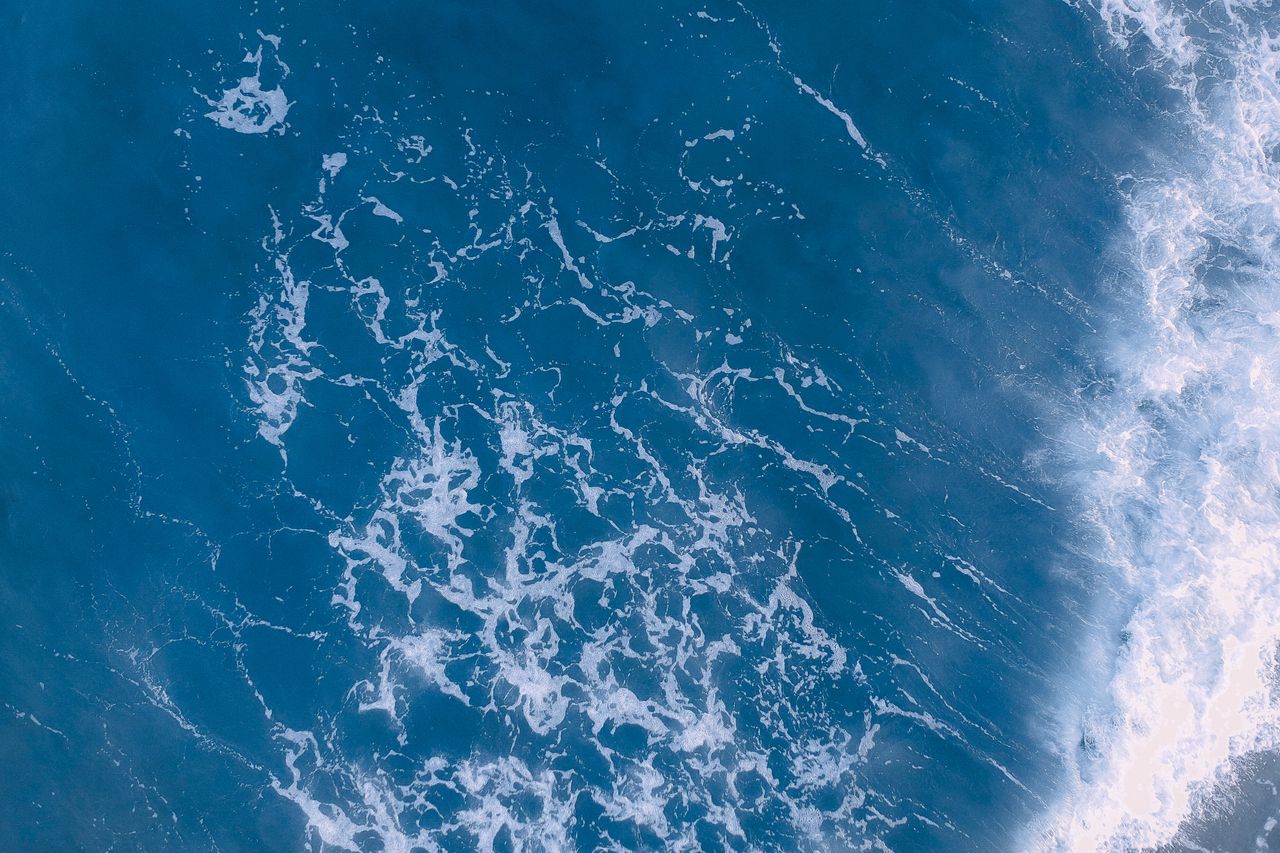 stunning aerial view capturing vibrant blue ocean waves with white foa