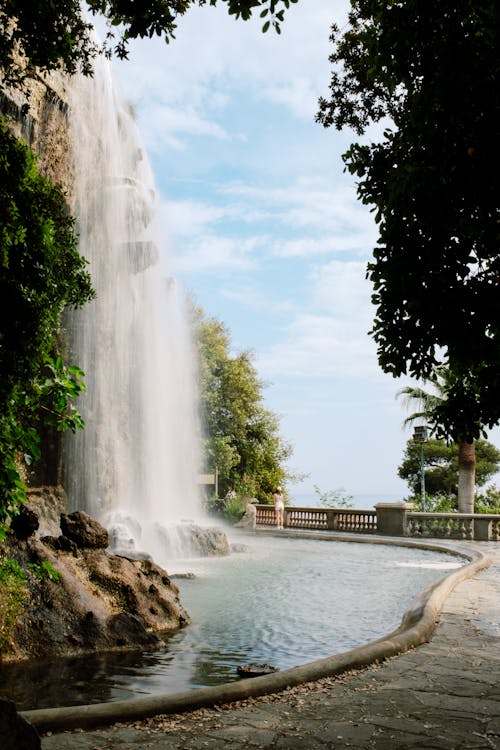 A waterfall is seen in the middle of a park