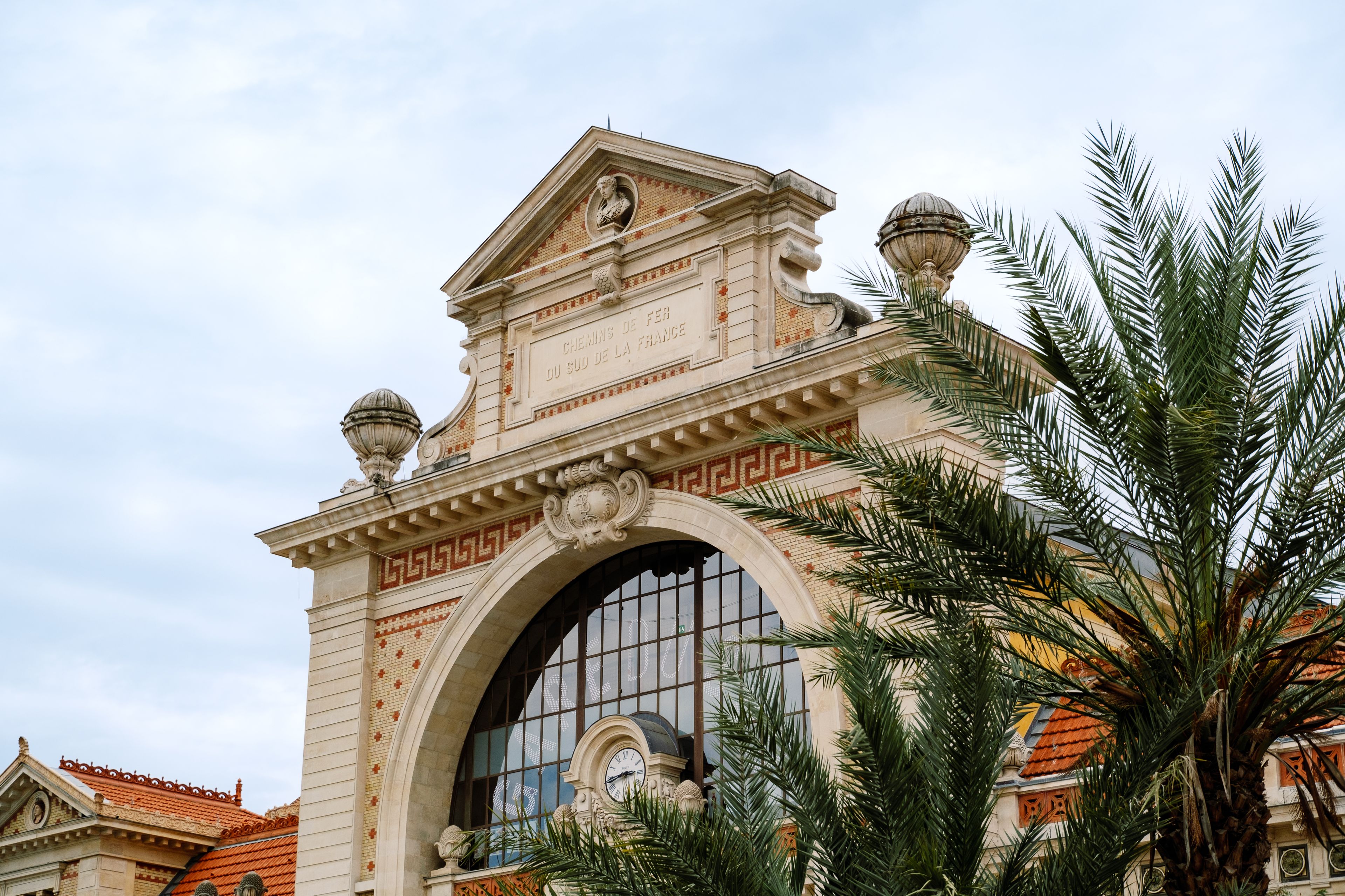 Façade d'architecture Riviera encadrée de palmiers à Nice