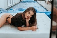 一位黑发妇女坐在皮革沙发上，在水池边享受休闲时光