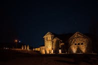 在星光熠熠的夜空下，矗立着一座灯火通明的石豪宅，散发着宁静而神秘的魅力