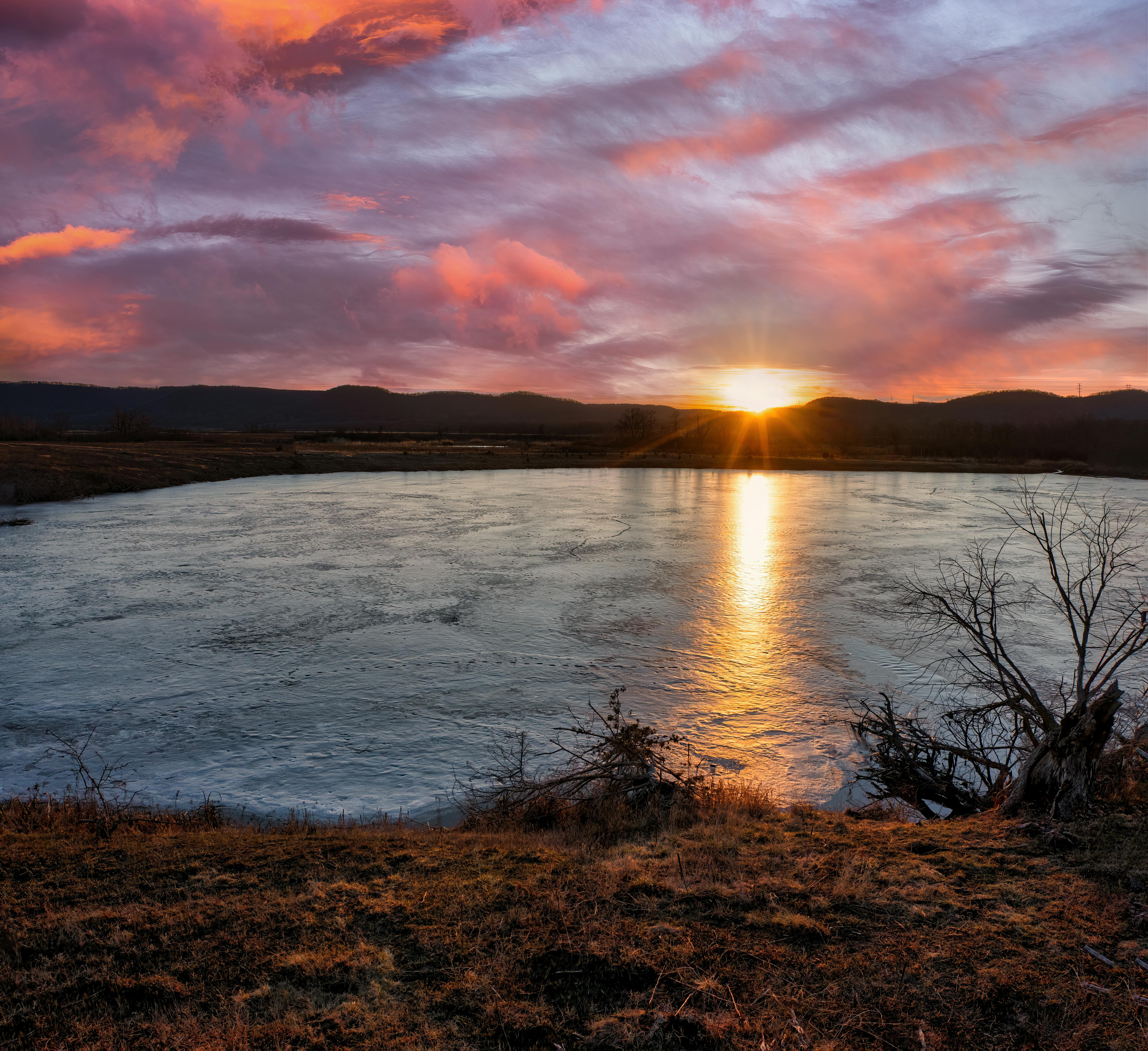 Beautiful sunset reflecting on a tranquil lake in West Newton, Minnesota.