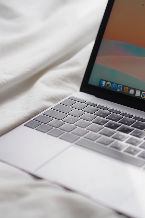 A laptop computer is shown on a bed