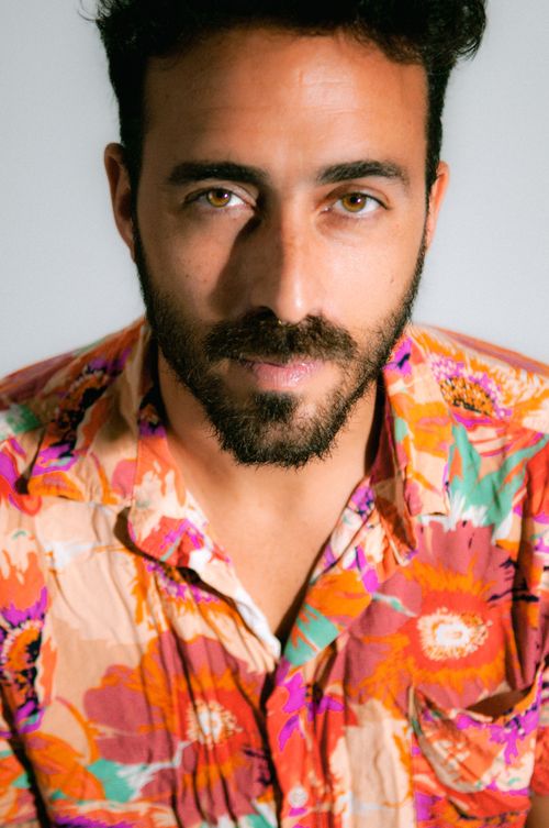 Studio portrait of a bearded man in a bright floral camp collar shirt — photo by Emiliano Vittoriosi on Pexels
