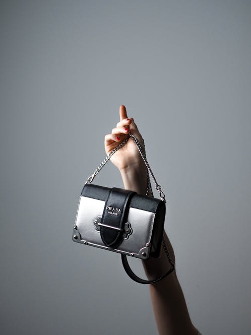 A woman holding a small black and white purse